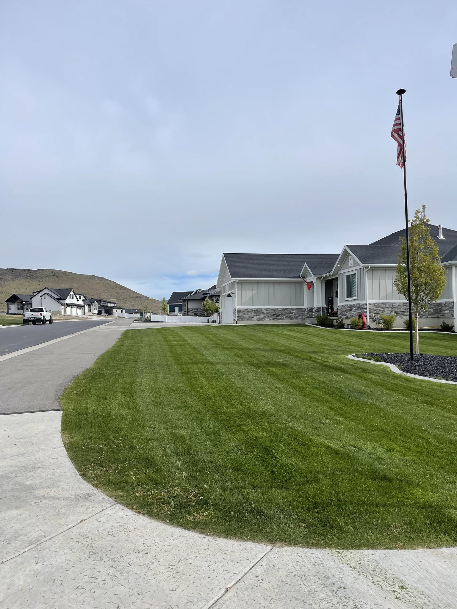 A neatly mown Happy Lawns corner lawn in a Utah neighborhood